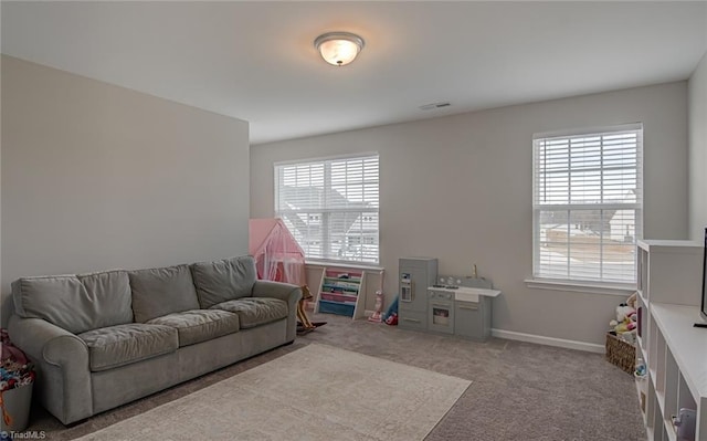 carpeted living area featuring visible vents and baseboards