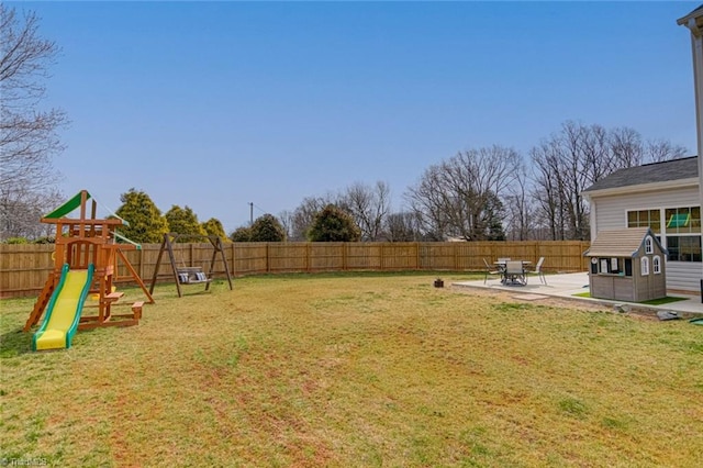 view of yard featuring a patio area, a fenced backyard, and a playground