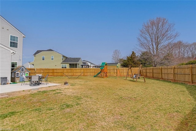 view of yard with a fenced backyard, a playground, and a patio