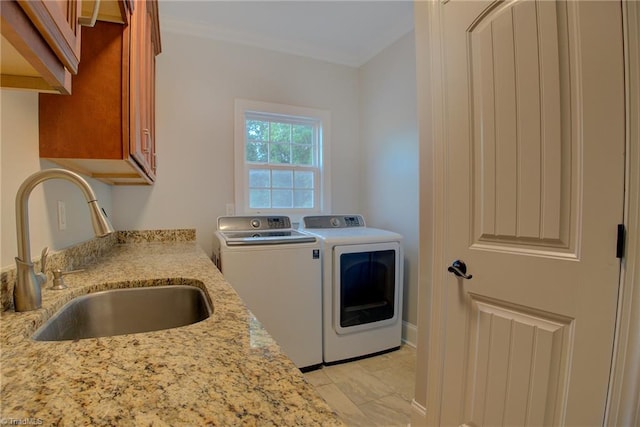 laundry room featuring washing machine and clothes dryer, sink, light tile patterned flooring, and cabinets