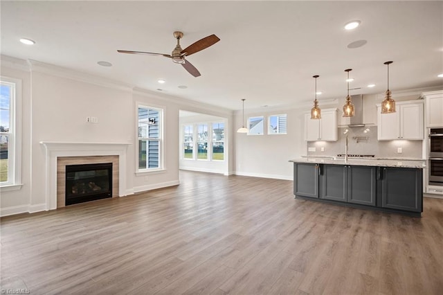 kitchen featuring pendant lighting, white cabinetry, ornamental molding, and hardwood / wood-style flooring