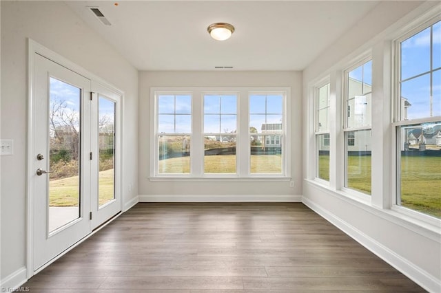 unfurnished sunroom featuring a wealth of natural light and a water view