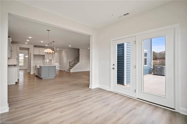 entryway with sink and light hardwood / wood-style flooring