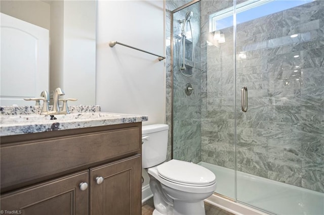 bathroom featuring vanity, toilet, and walk in shower