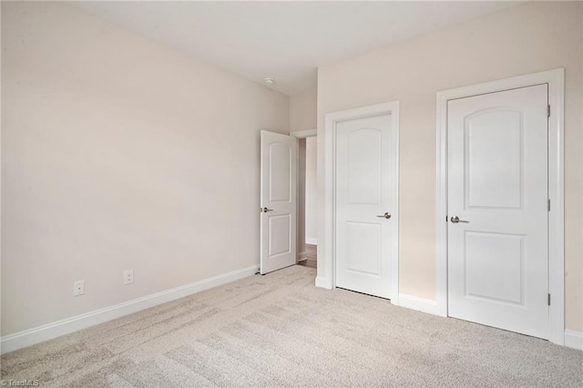 unfurnished bedroom featuring light carpet