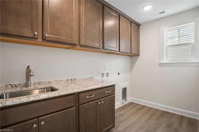 clothes washing area with sink, washer hookup, cabinets, electric dryer hookup, and wood-type flooring