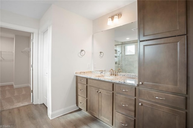 bathroom with vanity, an enclosed shower, and hardwood / wood-style flooring