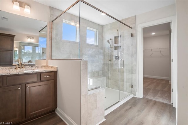 bathroom with vanity, wood-type flooring, and walk in shower