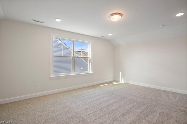 carpeted empty room with lofted ceiling