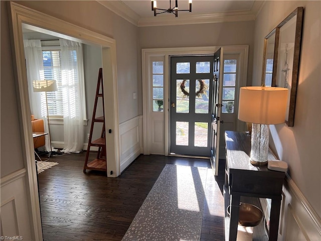 entryway featuring dark hardwood / wood-style flooring, crown molding, and an inviting chandelier