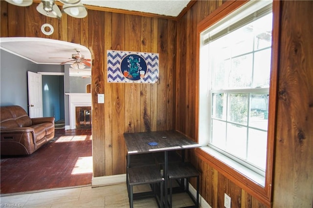 dining room with ceiling fan and wood walls