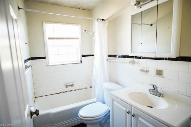 full bathroom with shower / bath combo, tile walls, vanity, a textured ceiling, and toilet