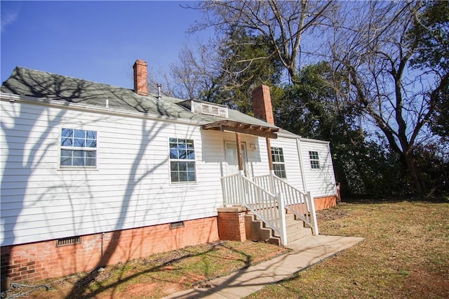 rear view of property featuring a lawn