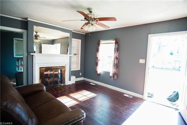 living room with ceiling fan, ornamental molding, and dark hardwood / wood-style flooring