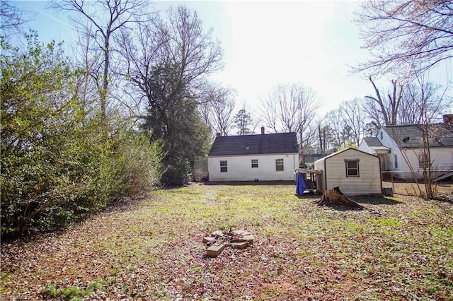 rear view of property with a lawn and a shed