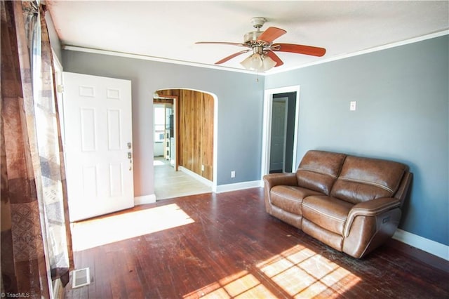 unfurnished living room with crown molding, wood-type flooring, and ceiling fan