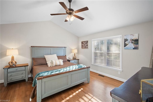 bedroom with baseboards, visible vents, lofted ceiling, ceiling fan, and wood finished floors