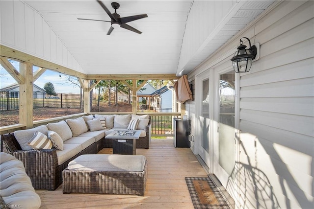 wooden terrace with an outdoor hangout area, fence, and a ceiling fan