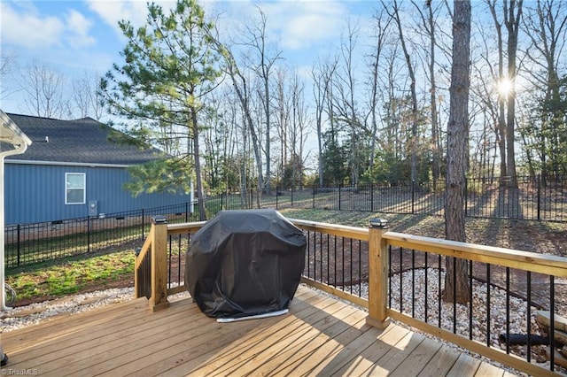 wooden terrace featuring a fenced backyard and a grill