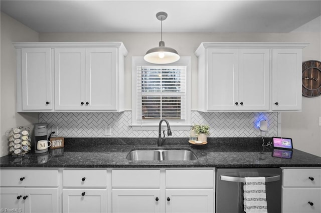 kitchen with hanging light fixtures, backsplash, stainless steel dishwasher, white cabinetry, and a sink