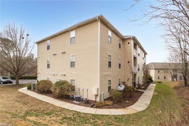 view of side of home featuring a yard and central air condition unit