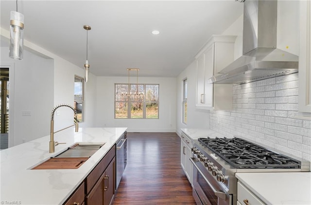 8812 Rudy Dr, Kernersville, NC 27284 - kitchen with wall chimney exhaust hood, appliances with stainless steel finishes, a sink, dark wood finished floors, and decorative backsplash