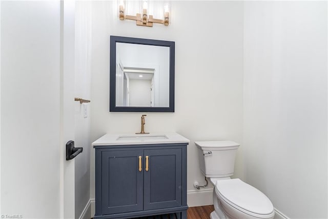 bathroom featuring toilet, vanity, and hardwood / wood-style flooring