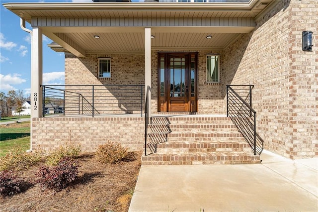 8812 Rudy Dr, Kernersville, NC 27284 - view of exterior entry featuring brick siding and covered porch