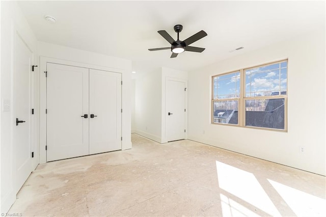 unfurnished bedroom featuring ceiling fan and a closet