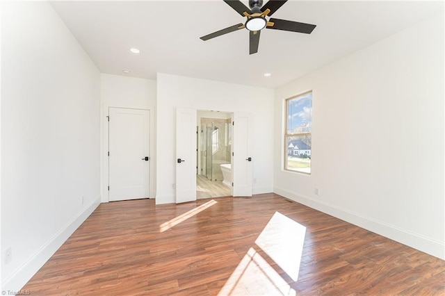 unfurnished bedroom featuring ensuite bath, dark hardwood / wood-style floors, and ceiling fan