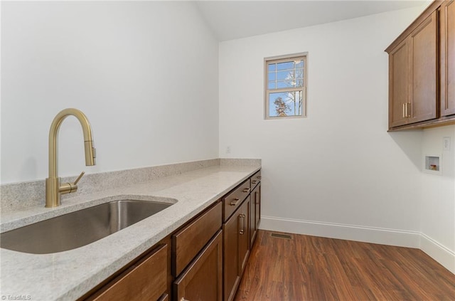 kitchen with dark wood-type flooring, sink, and light stone countertops