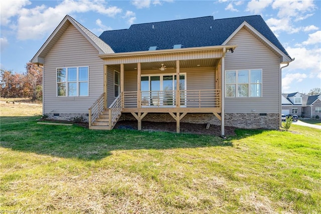 back of property featuring ceiling fan and a lawn