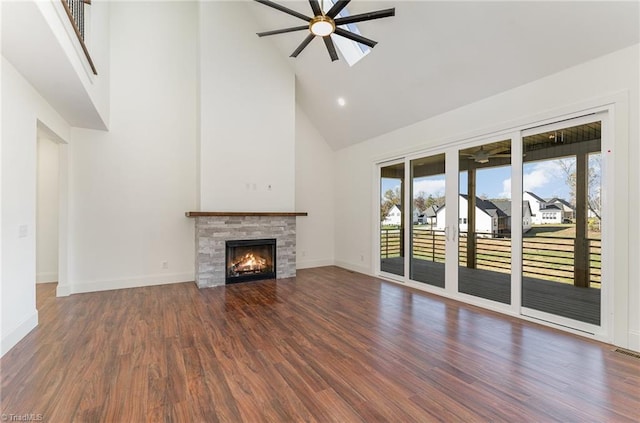 unfurnished living room featuring high vaulted ceiling, a fireplace, dark hardwood / wood-style floors, and ceiling fan