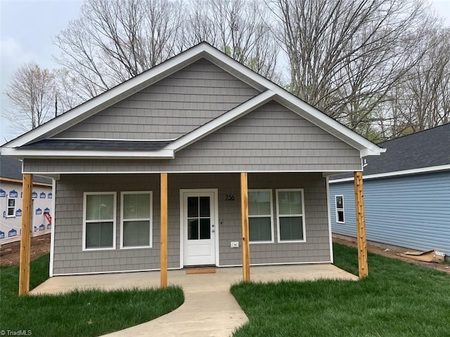 view of front of house featuring covered porch and a front lawn