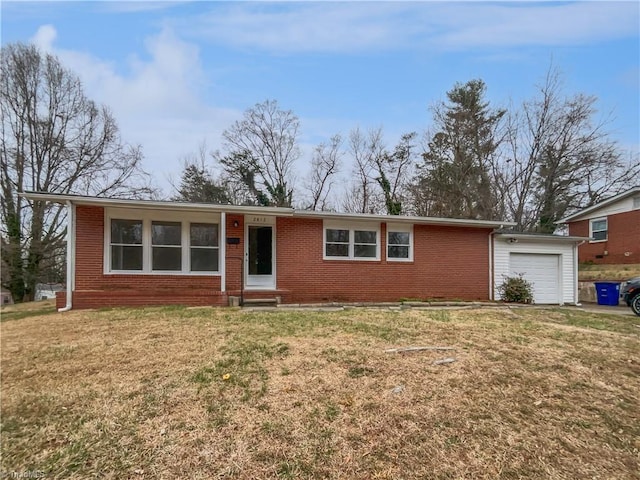 ranch-style home featuring a garage, brick siding, a front yard, and entry steps