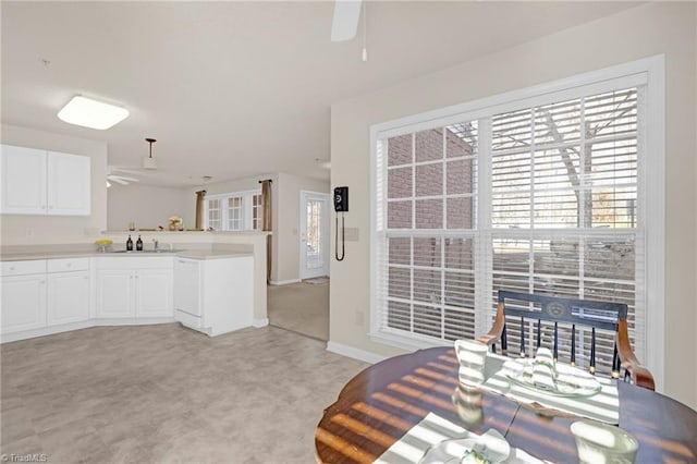 kitchen with light carpet, white cabinets, ceiling fan, decorative light fixtures, and kitchen peninsula