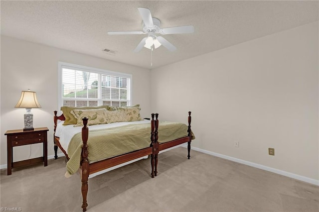 carpeted bedroom featuring ceiling fan and a textured ceiling