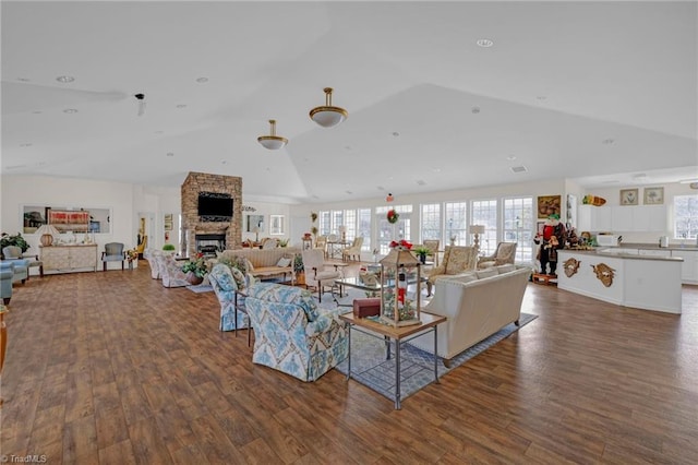 living room featuring a fireplace, dark hardwood / wood-style floors, and vaulted ceiling