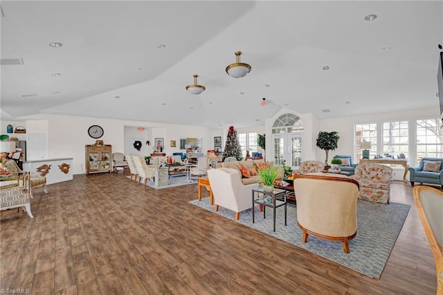 living room with hardwood / wood-style flooring, a healthy amount of sunlight, and lofted ceiling