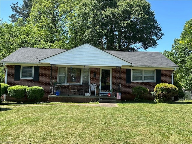 735 Fairfield St, Burlington, NC 27215 - view of front facade with a porch, a front lawn, and brick siding