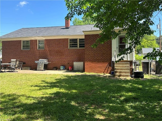 735 Fairfield St, Burlington, NC 27215 - rear view of house featuring brick siding, a chimney, entry steps, and a patio