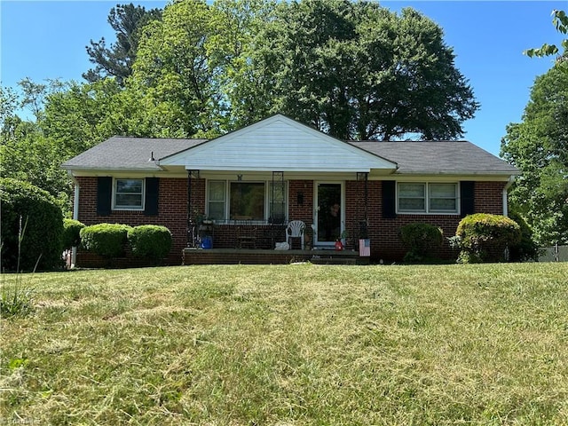 735 Fairfield St, Burlington, NC 27215 - view of front of house featuring covered porch, a front lawn, and brick siding