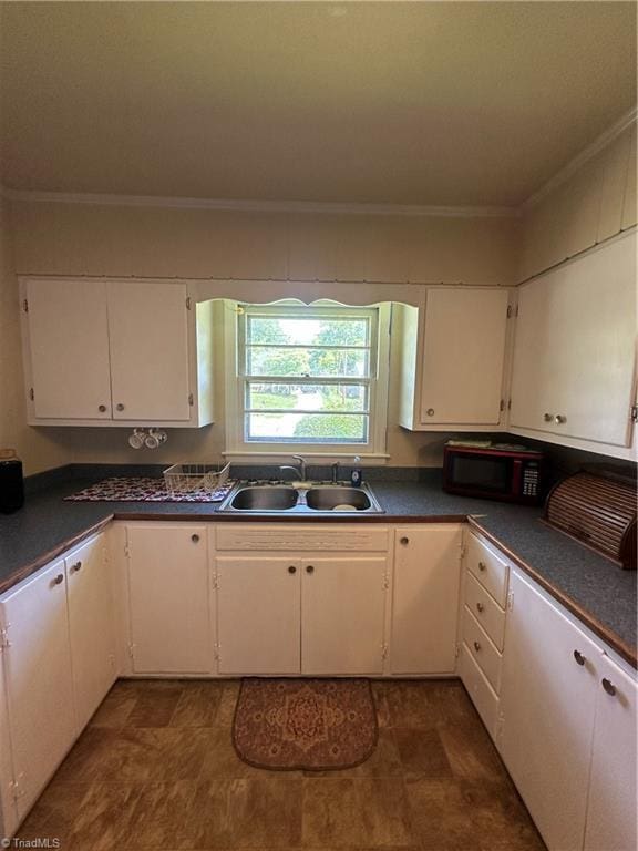 735 Fairfield St, Burlington, NC 27215 - kitchen featuring black microwave, a sink, crown molding, white cabinetry, and dark countertops