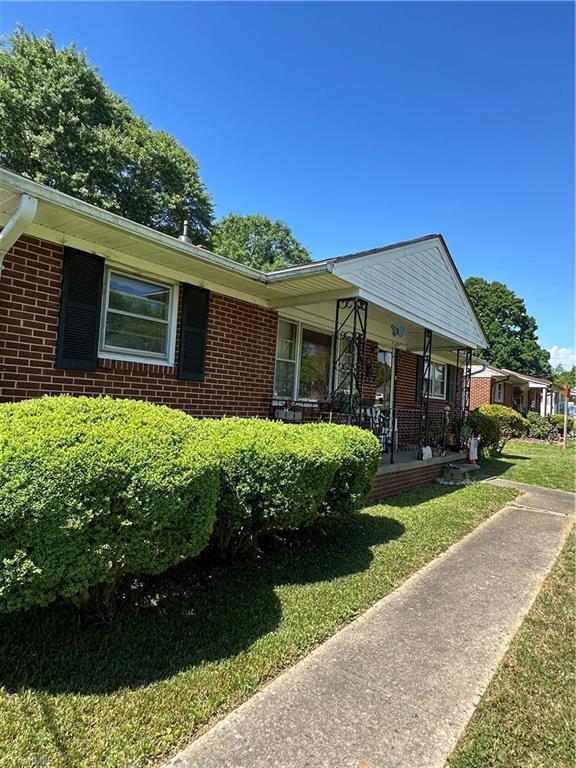 735 Fairfield St, Burlington, NC 27215 - view of front of home with brick siding, a front yard, and covered porch