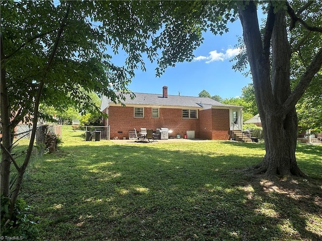 735 Fairfield St, Burlington, NC 27215 - back of house featuring a patio, brick siding, and a chimney