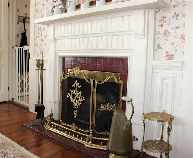 room details featuring wood-type flooring and a tiled fireplace