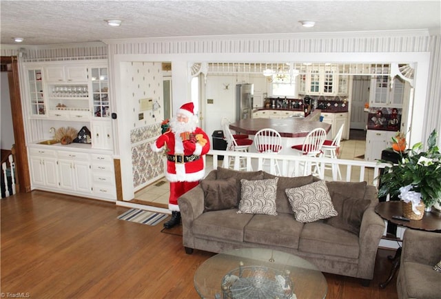 living room featuring hardwood / wood-style floors, a textured ceiling, and ornamental molding