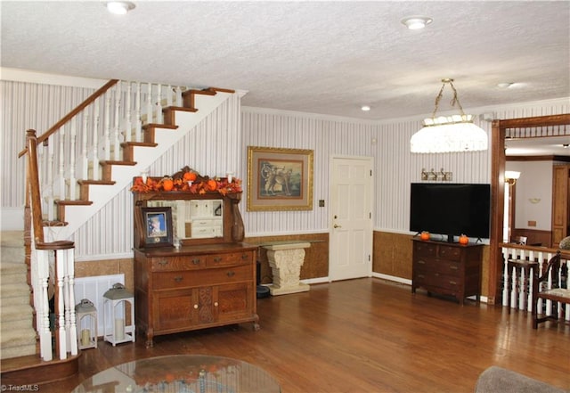 living room featuring a textured ceiling, crown molding, and dark hardwood / wood-style floors