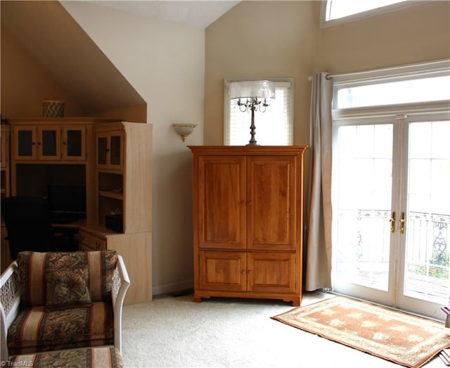 sitting room with french doors, light colored carpet, a healthy amount of sunlight, and vaulted ceiling