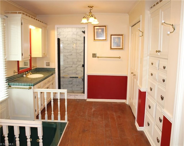 corridor with crown molding, sink, dark wood-type flooring, and a notable chandelier